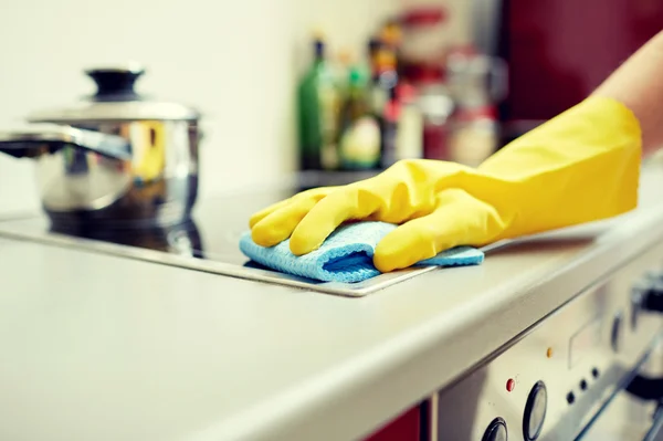 Close up de mulher de limpeza fogão em casa cozinha — Fotografia de Stock