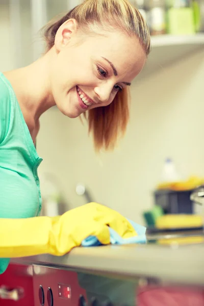 Donna felice pulizia fornello a casa cucina — Foto Stock