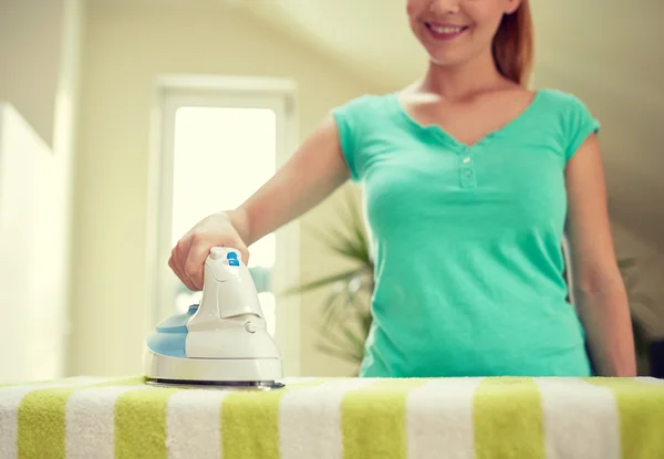 Primer plano de la mujer feliz con plancha de hierro en casa — Foto de Stock