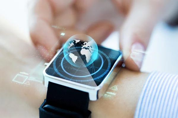 Close-up van de hand met globe hologram op smartwatch — Stockfoto