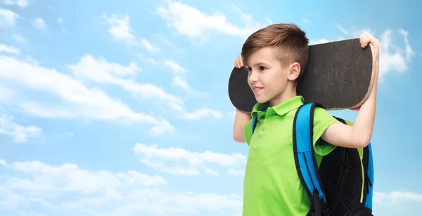 Menino estudante feliz com mochila e skate — Fotografia de Stock