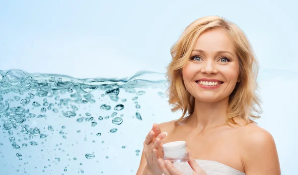 Happy middle aged woman with moisturizing cream — Stok fotoğraf