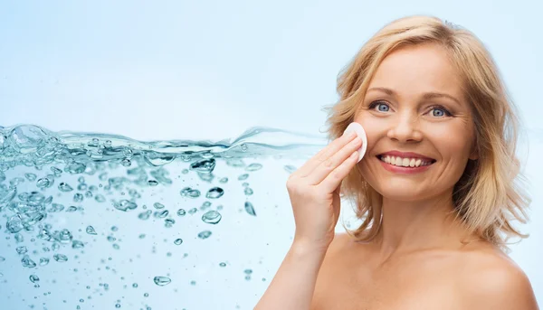 Szczęśliwa kobieta czyszczenie twarzy z wacikiem — Zdjęcie stockowe
