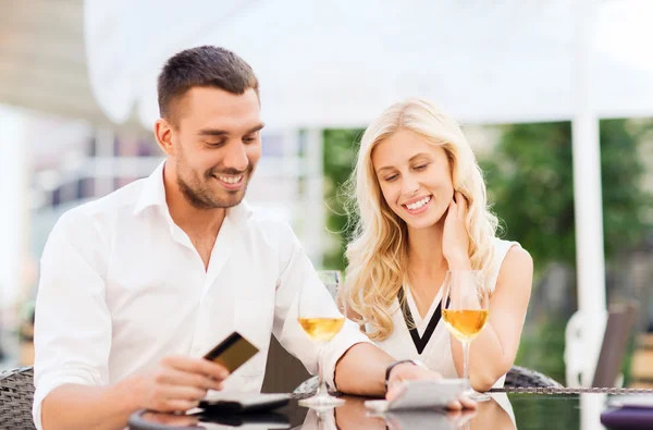 Feliz pareja con tarjeta bancaria y factura en el restaurante — Foto de Stock