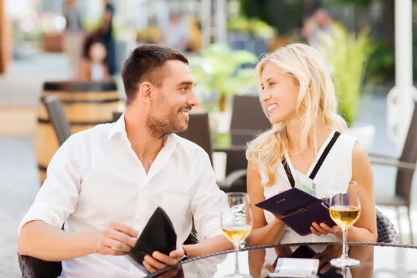 Coppia felice con portafoglio pagare bolletta al ristorante — Foto Stock