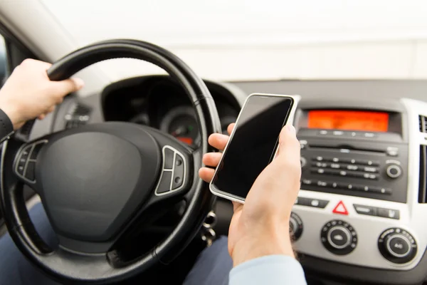 Primer plano de la mano del hombre con coche de conducción de teléfonos inteligentes —  Fotos de Stock