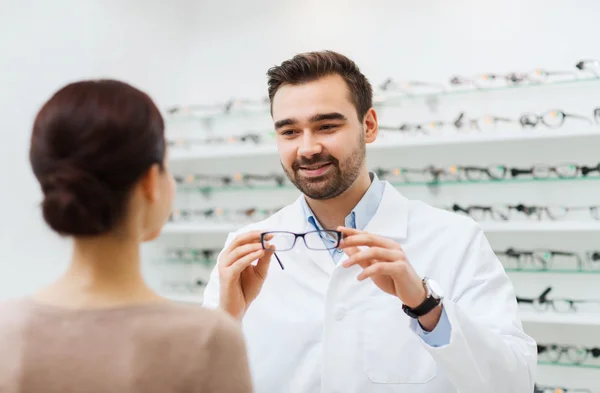 Frau und Optikerin zeigen Brille im Optikgeschäft — Stockfoto