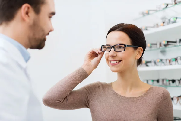 Mujer la elección de gafas en la tienda de óptica —  Fotos de Stock