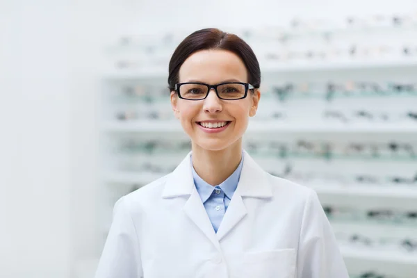 Woman optician in glasses and coat at optics store — Stok fotoğraf