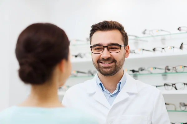 Vrouw en opticien in glazen op optica winkel — Stockfoto