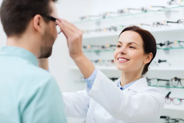 Ottico mettere gli occhiali per l'uomo al negozio di ottica — Foto Stock