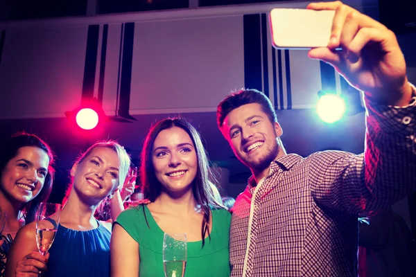 Vänner med glasögon och smartphone i club — Stockfoto