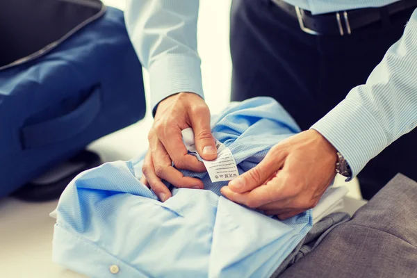 Geschäftsmann packt Kleidung in Reisetasche — Stockfoto