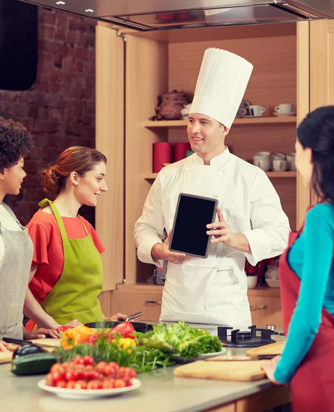 Ευτυχισμένος γυναίκες με σεφ και tablet pc στην κουζίνα — Φωτογραφία Αρχείου