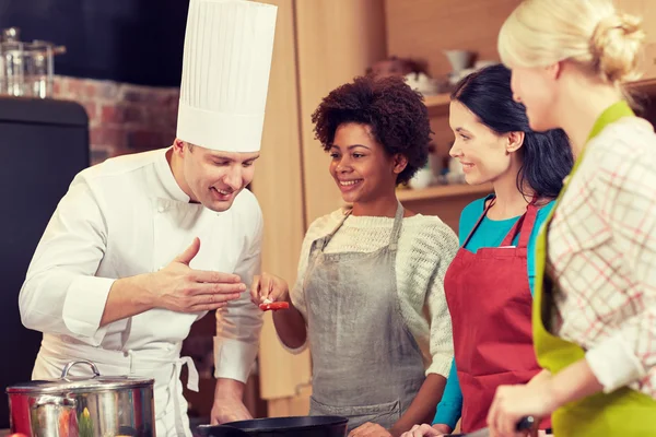 Gelukkig vrouwen en chef kok koken in de keuken — Stockfoto