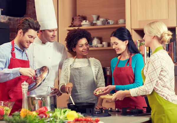 Amigos felices y cocinero cocinar en la cocina — Foto de Stock