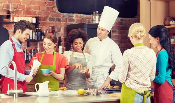 Happy friends en chef kok koken in de keuken — Stockfoto