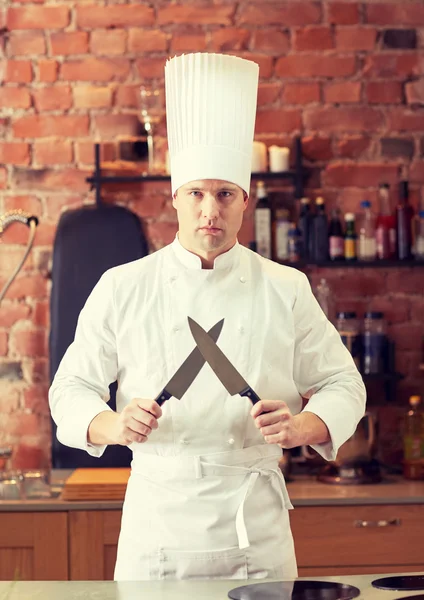 Zadowolony mężczyzna kucharz w kuchni z nożem — Zdjęcie stockowe
