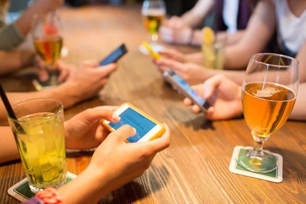 Närbild på händerna med smartphones på restaurang — Stockfoto