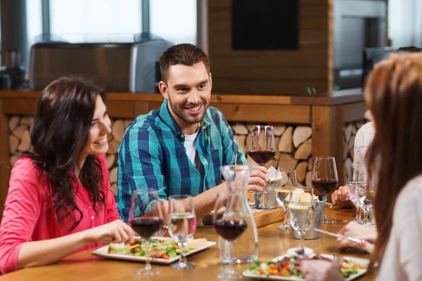 Vrienden dineren en wijn drinken in restaurant — Stockfoto