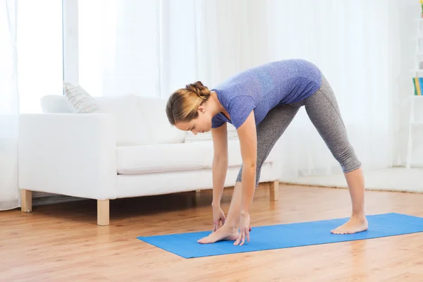 Mujer haciendo yoga intenso estiramiento pose en la estera — Foto de Stock