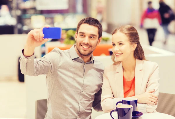 Feliz pareja con smartphone tomando selfie en el centro comercial —  Fotos de Stock