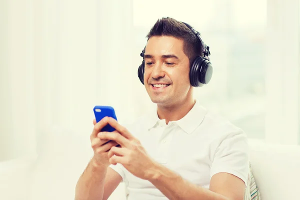 Homem feliz com smartphone e fones de ouvido — Fotografia de Stock
