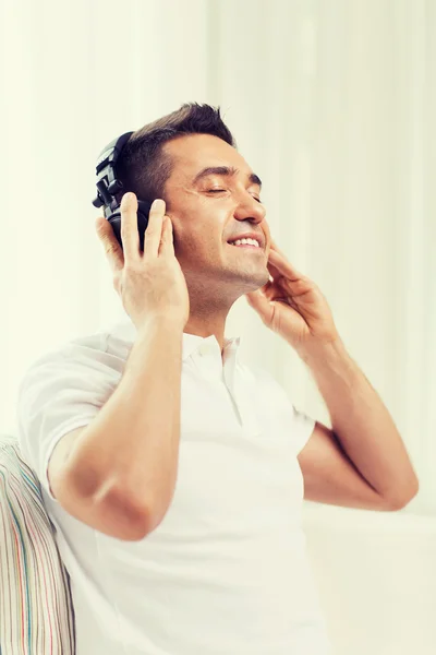 Gelukkig man in koptelefoon luisteren naar muziek thuis — Stockfoto