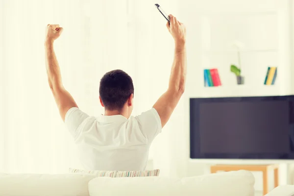 Homem assistindo tv e equipe de apoio em casa — Fotografia de Stock