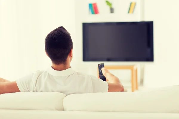 Homem assistindo tv e mudando de canais em casa — Fotografia de Stock