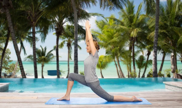 Glückliche Frau macht Yoga in niedrigem Ausfallschritt über Strand — Stockfoto