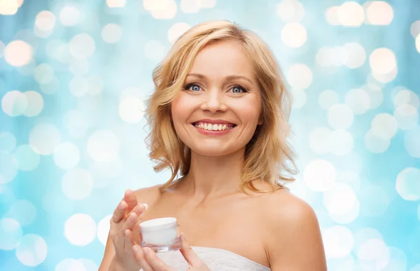 Mulher de meia idade feliz com frasco de creme — Fotografia de Stock