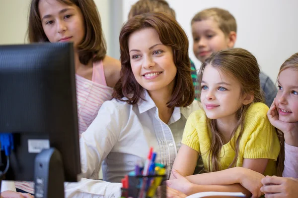 Group of kids with teacher and computer at school — Stock Photo, Image