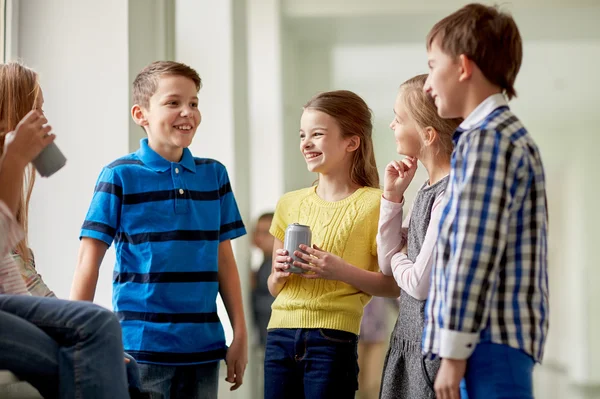 Grupo de crianças da escola com latas de refrigerante no corredor — Fotografia de Stock