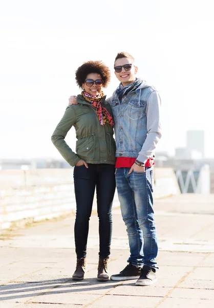 Happy teenage friends in shades hugging outdoors — Stock Photo, Image