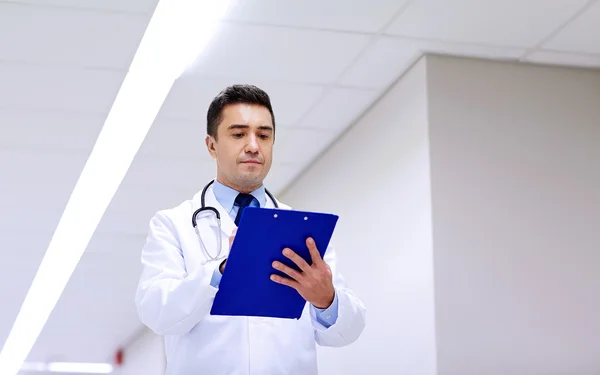 Doctor with clipboard at hospital corridor — Stock Photo, Image