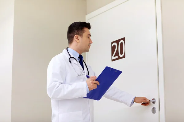 Lekarz ze schowka, otwierając drzwi oddziale szpitala — Zdjęcie stockowe