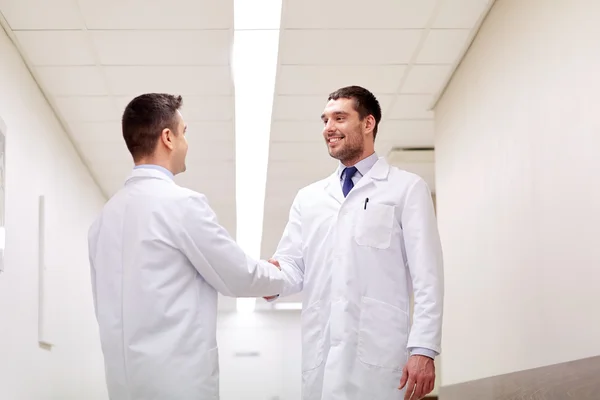 Médecins souriants à l'hôpital faisant poignée de main — Photo