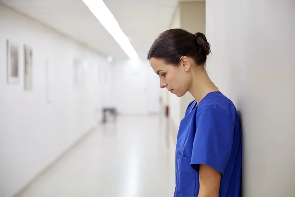 Sad female nurse at hospital corridor — Stock Photo, Image