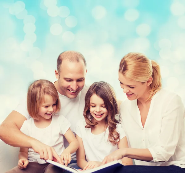 Família feliz com livro em casa — Fotografia de Stock