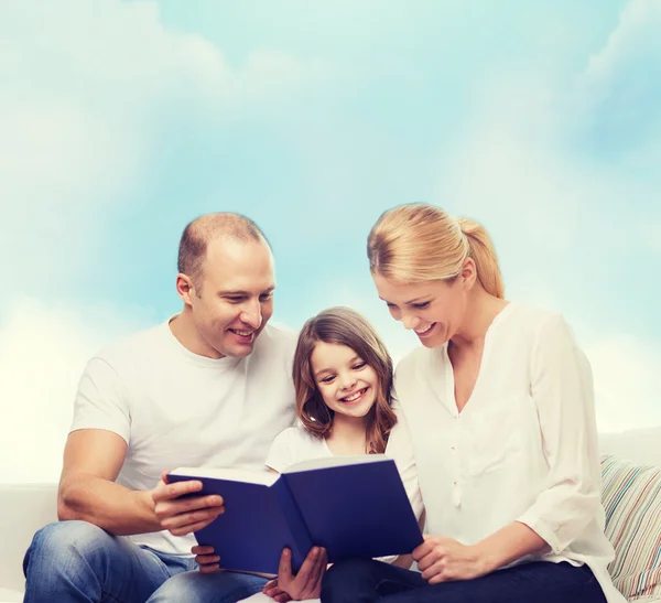 Famille heureuse avec livre à la maison — Photo