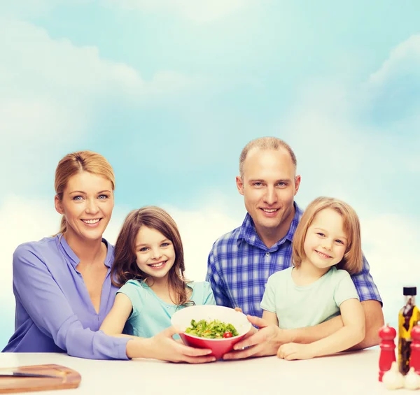 Lycklig familj med två barn med sallad hemma — Stockfoto