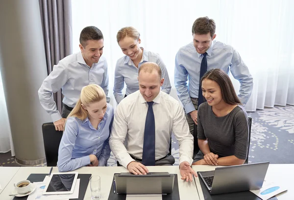 Gente d'affari sorridente con computer portatile in ufficio — Foto Stock