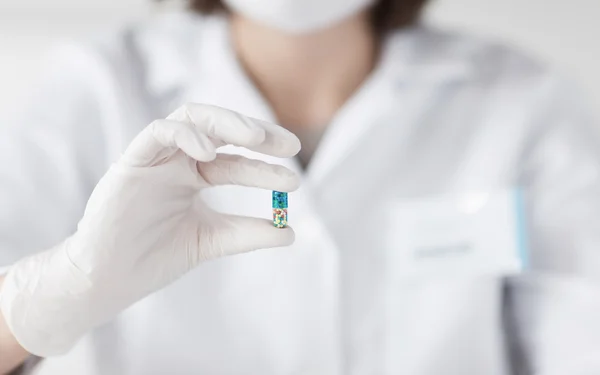 Perto de cientista segurando pílula em laboratório — Fotografia de Stock