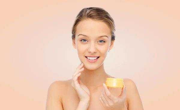 Feliz joven mujer aplicando crema a su cara —  Fotos de Stock