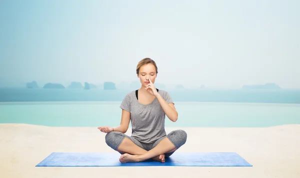 Mulher fazendo meditação de ioga em lótus posar no tapete — Fotografia de Stock
