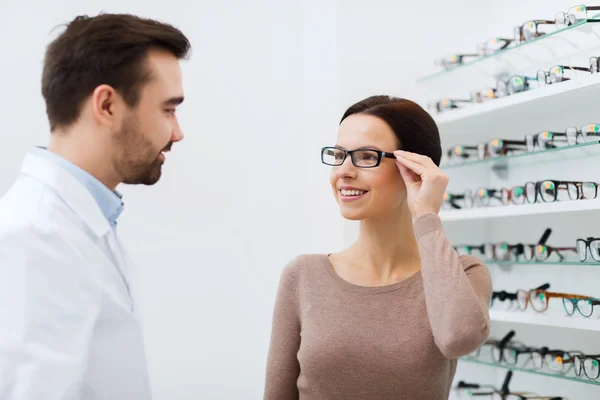 Mulher escolhendo óculos na loja de óptica — Fotografia de Stock