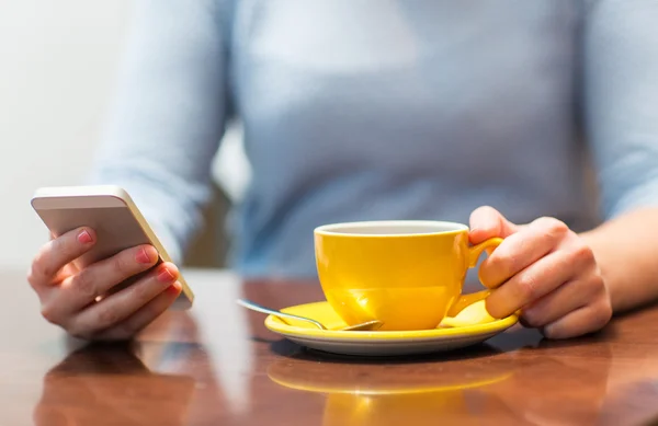 Закрыть женщину со смартфоном и чашкой кофе — стоковое фото