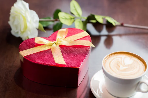 Close up of gift box and coffee cup on table — Stock Photo, Image