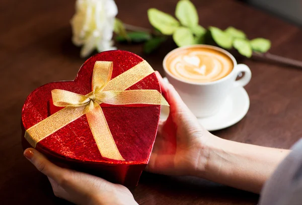 Primer plano de las manos sosteniendo caja de regalo en forma de corazón —  Fotos de Stock